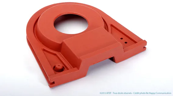 Pièce moulée rouge en élastomère, avec un perçage circulaire